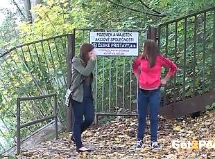 Two cute girls pee in the leaves outdoors